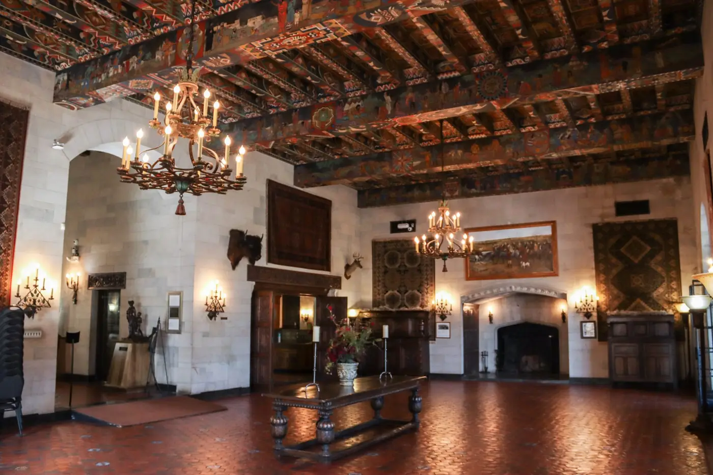 Great hall with painted beam ceiling and chandeliers at Marland Mansion